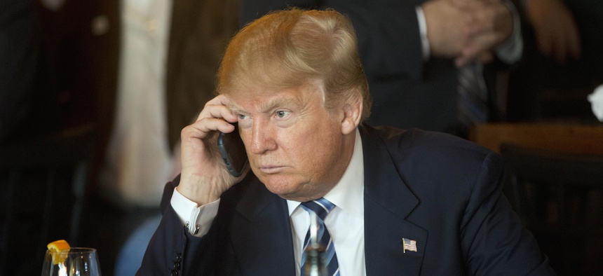 Republican presidential candidate Donald Trump listens to his mobile phone during a lunch stop, Thursday, Feb. 18, 2016, in North Charleston, S.C.