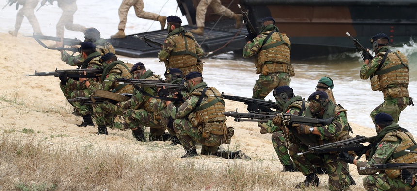 British Royal Marines and Portuguese fuzileiros, exit amphibious boats during the NATO Trident Juncture exercise 2015 in Troia, south of Lisbon, Thursday, Nov. 5, 2015.