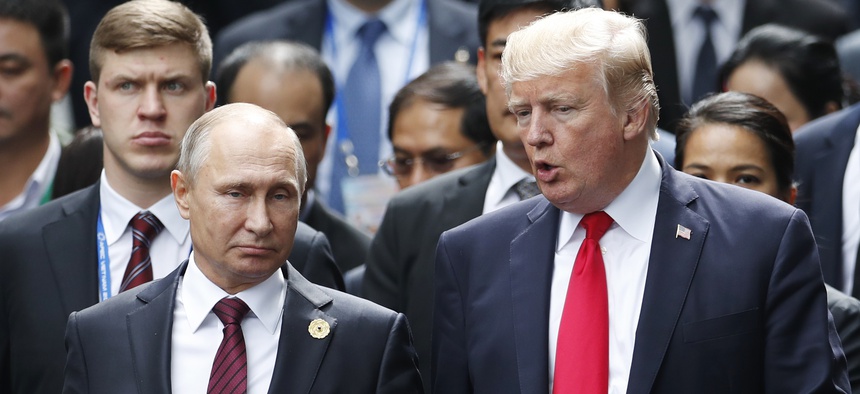 U.S. President Donald Trump and Russia's President Vladimir Putin talk during the family photo session at the APEC Summit in Danang, Saturday, Nov. 11, 2017.