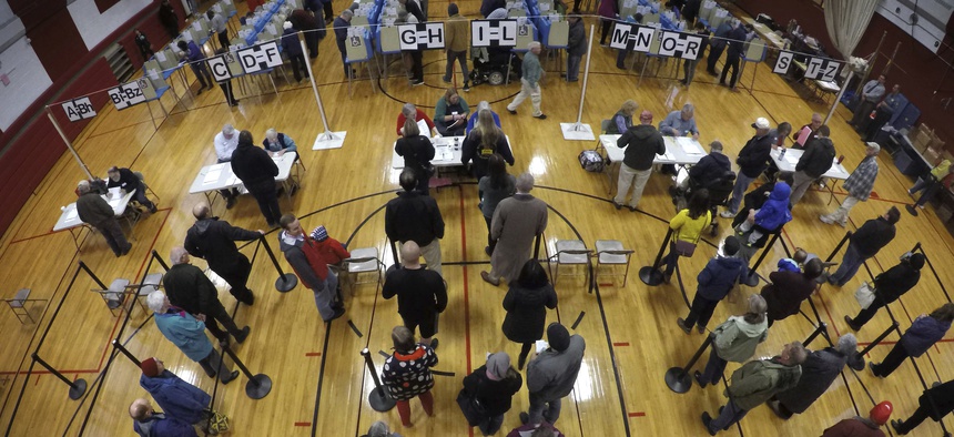 Voters wait in line in the gymnasium at Brunswick Junior High School to receive their ballots for the mid-term election, Tuesday, Nov. 6, 2018, in Brunswick, Maine.