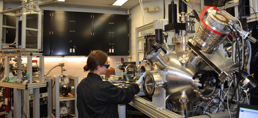 Ashley Wissel, Purdue University undergraduate student, works with the pulsed laser deposition chamber in the Materials and Manufacturing Directorate. This is used to study growth of thin layers of material at low temperatures.