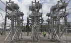 In this Wednesday, May 20, 2015 photo, contractors walk past a capacitor bank at an AEP electrical transmission substation in Westerville, Ohio. In this Wednesday, May 20, 2015 photo, contractors walk past a capacitor bank at an AEP electrical transmission substation in Westerville, Ohio.