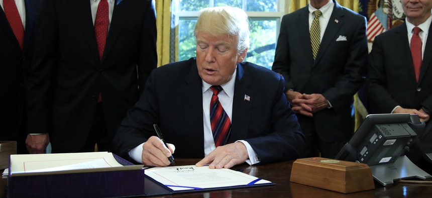 President Donald Trump signs the “America’s Water Infrastructure Act of 2018” into law during a ceremony in the Oval Office at the White House in Washington, Tuesday, Oct. 23, 2018.