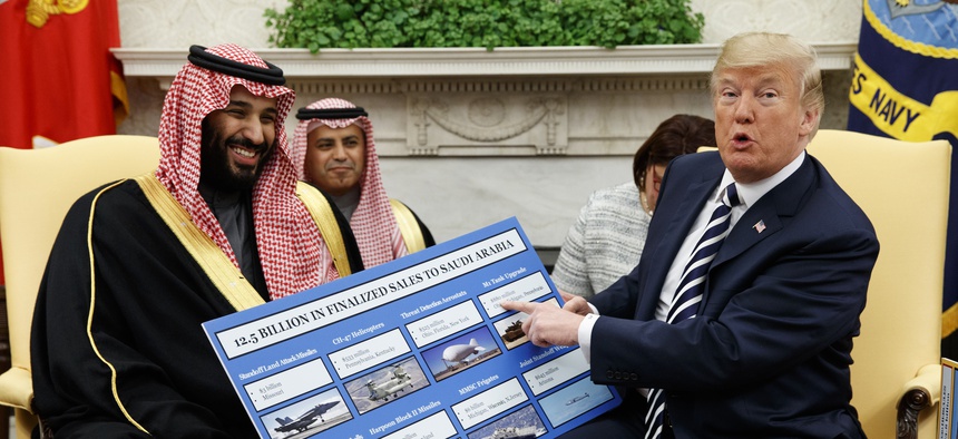 President Donald Trump shows a chart highlighting arms sales to Saudi Arabia during a meeting with Saudi Crown Prince Mohammed bin Salman in the Oval Office of the White House, Tuesday, March 20, 2018, in Washington.