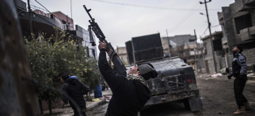 In this Sunday, Dec. 18, 2016 file photo, a member of the Iraqi Special Forces shoots his machine gun against an Islamic State militant drone n the al-Barid district in Mosul, Iraq.