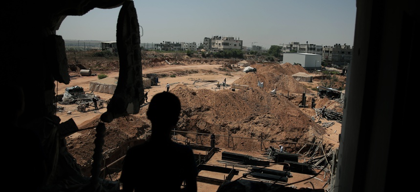 In this July 23, 2015 photo, a Palestinian boy looks from his family's house which was destroyed during the 2014 summer war between Israel and Hamas, as the long-awaited reconstruction began in Shijaiyah neighborhood eastern Gaza City.