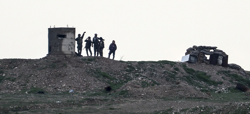Fighters of People's Protection Units, or YPG, gather at their outpost west of the city of Kobani, northern Syria, Tuesday, Dec. 18, 2018.