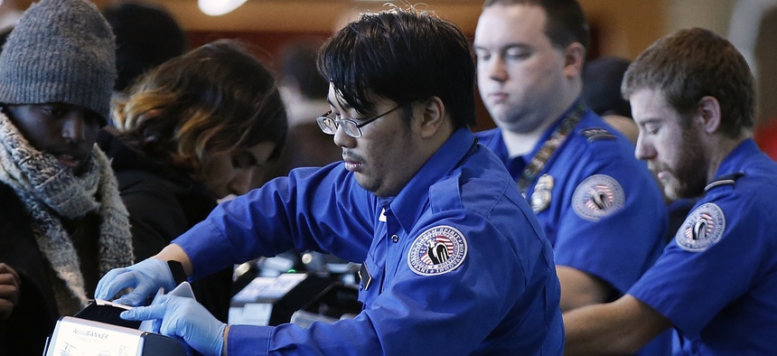 Transportation Security Administration officers check boarding passes and identification at Logan International Airport in Boston, Sunday, Dec. 23, 2018.