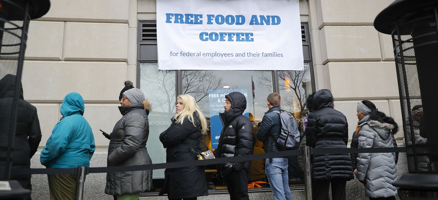 People wait in line at Chef Jose Andres' World Central Kitchen for free meals to workers effected by the government shutdown in Washington, Wednesday, Jan. 16, 2019.