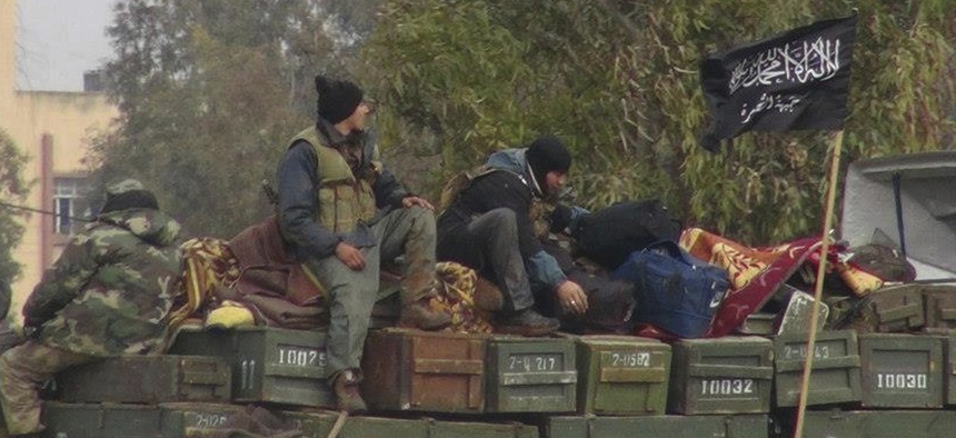 In this Friday, Jan. 11, 2013 file photo, rebels from al-Qaida-affiliated Jabhat al-Nusra, also known as the Nusra Front, sit on a truck full of ammunition at Taftanaz air base, that was captured by the rebels in Idlib province, northern Syria.