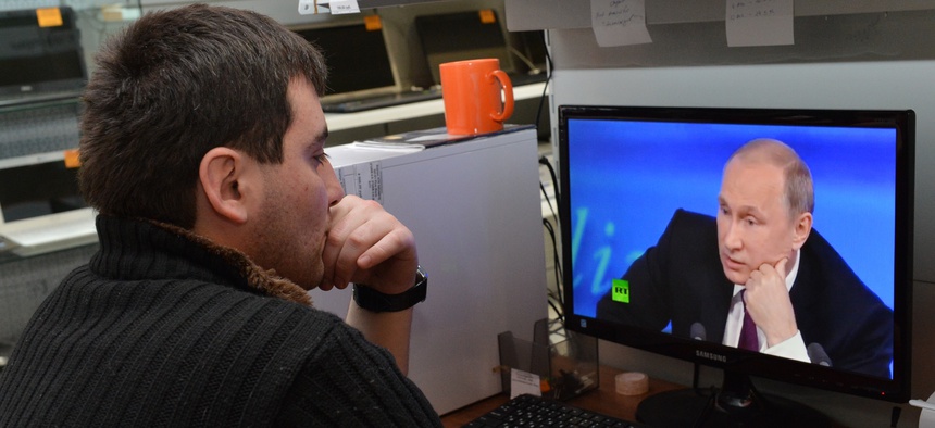 A customer watches Russian President Vladimir Putin on a computer screen in an electronic hypermarket in Grozny, regional Chechen capital, Russia, Thursday, Dec. 18, 2014.
