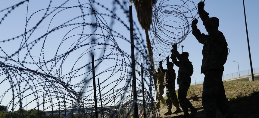 In this Nov. 16, 2018, file photo, members of the U.S. military install multiple tiers of concertina wire along the banks of the Rio Grande near the Juarez-Lincoln Bridge at the U.S.-Mexico border in Laredo, Texas.