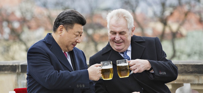 Chinese President Xi Jinping, left, and Czech Republic's President Milos Zeman, right, clink glasses of beer on the terrace of the Strahov Monastery in Prague, Czech Republic, Wednesday, March 30, 2016.