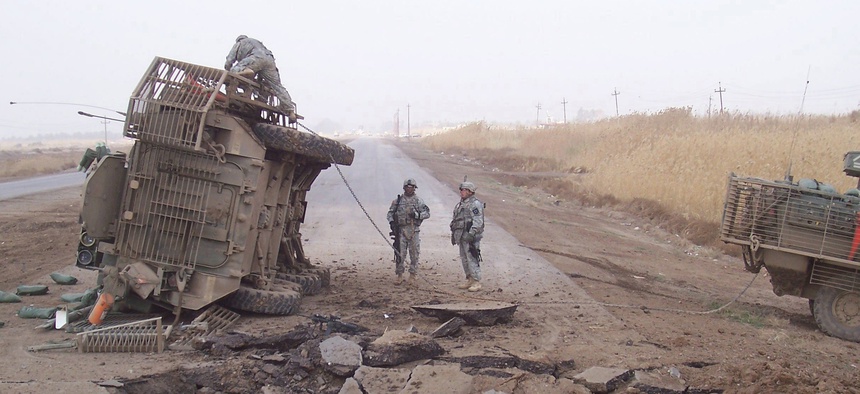 A Stryker fighting vehicle lies on its side after surviving a buried IED blast in 2007.