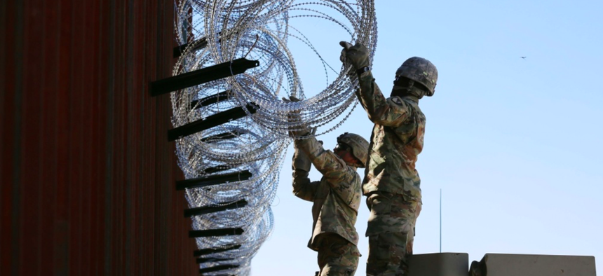 Soldiers assigned to 87th Sapper Company place concertina wire on a border wall near Douglas, Arizona, Nov. 15, 2018.