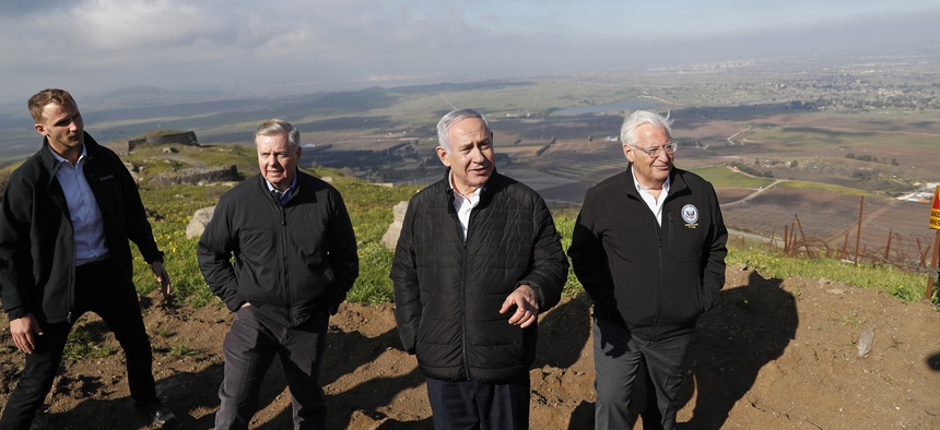 Israeli Prime Minister Benjamin Netanyahu, center, Republican U.S. Senator Lindsey Graham, second left, and U.S. Ambassador to Israel David Friedman, right, visit the border between Israel and Syria at the Israeli-held Golan Heights, March 11, 2019.