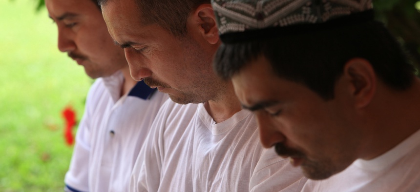 Former Guantanamo detainees pray in the courtyard of a Bermuda cottage in 2009. They are among four Chinese ethnic Uighurs who had just been released from U.S. military custody after nearly seven years in Guantanamo.
