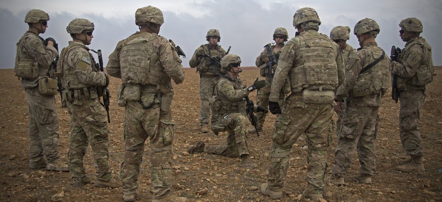 In this Nov. 7, 2018, photo released by the U.S. Army, U.S. soldiers gather for a brief during a combined joint patrol rehearsal in Manbij, Syria.