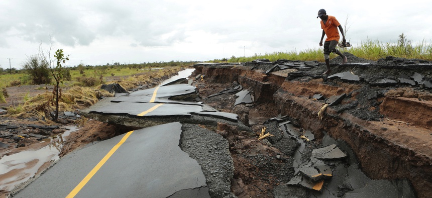 A man passes through a section of the road damaged by Cyclone Idai in Nhamatanda about 50 kilometres from Beira, in Mozambique, Friday March, 22, 2019.