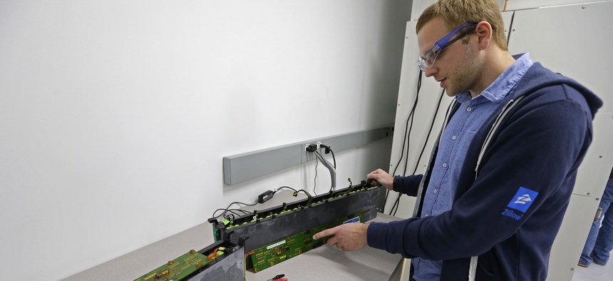 A PhD student at the University of Washington, holds a used lithium-ion battery at UW's Clean Energy Institute in Seattle, Feb. 13, 2017.