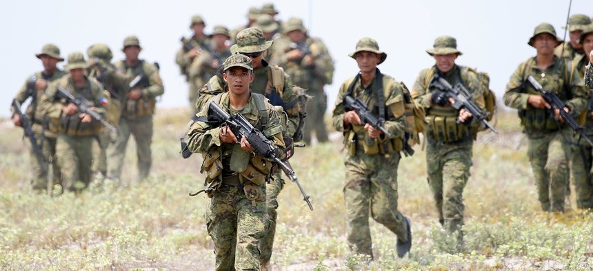 Philippine and U.S. Marines begin their assault after storming the beach during an amphibious landing exercise at the two-week joint U.S.-Philippines military exercise.
