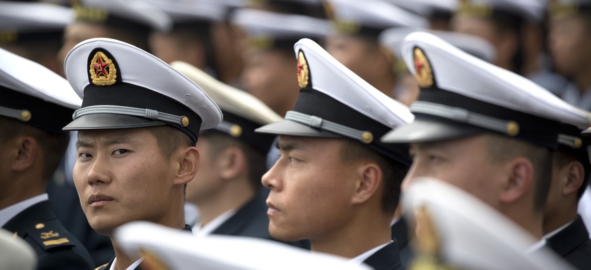 Chinese sailors sit before the start of a concert featuring Chinese and foreign military bands in Qingdao, Monday, April 22, 2019.