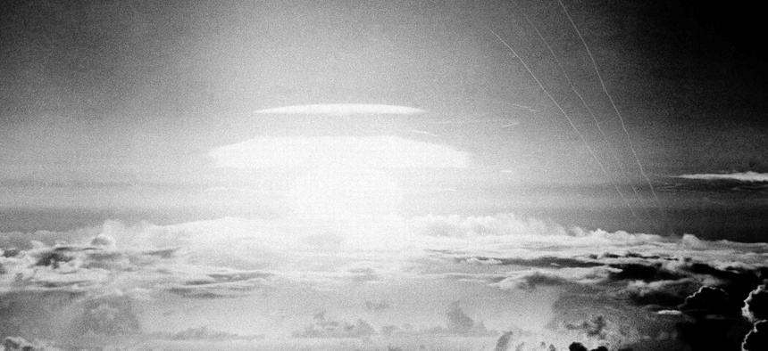 In this May 21, 1956, file photo, the fireball of a hydrogen bomb lights the Pacific sky a few seconds after the bomb was released over Bikini Atoll. Streamers at right are trails of rockets fired just before the blast for testing purposes.