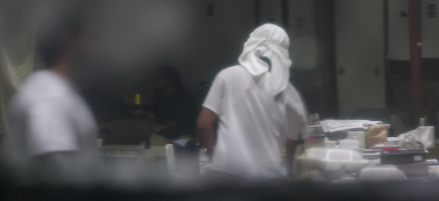 In this photo reviewed by U.S. military officials, detainees stand inside the Camp VI detention facility, Wednesday, April 17, 2019, in Guantanamo Bay Naval Base, Cuba.
