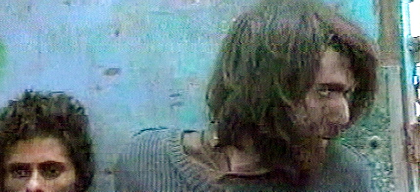 This file image taken Dec. 1, 2001, from television footage in Mazar-i-Sharif, Afghanistan, shows John Walker Lindh, right, claiming to be an American Taliban volunteer.