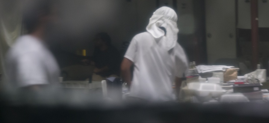 In this photo reviewed by U.S. military officials, detainees stand inside the Camp VI detention facility, Wednesday, April 17, 2019, in Guantanamo Bay Naval Base, Cuba.