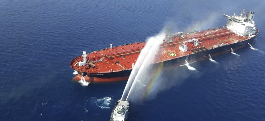 An Iranian navy boat sprays water to extinguish a fire on an oil tanker in the sea of Oman, Thursday, June 13, 2019.