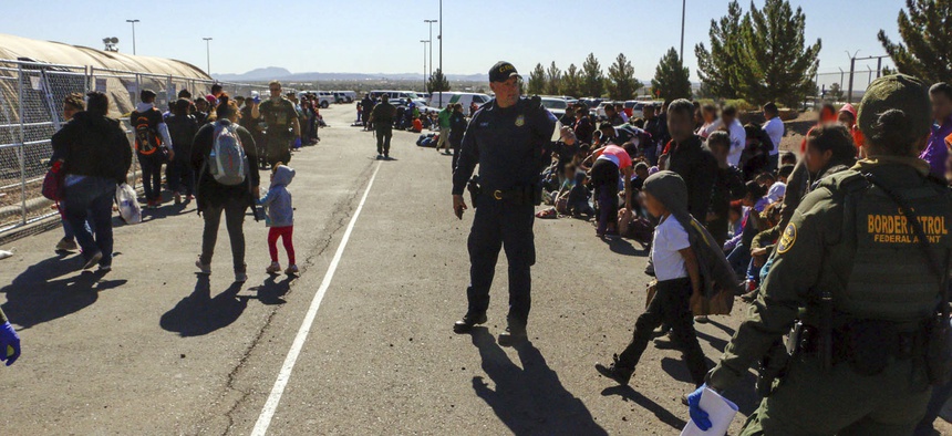 This May 29, 2019, photo released by U.S. Customs and Border Protection (CBP) shows some of 1,036 migrants who crossed the U.S.-Mexico border in El Paso, Texas, the largest that the Border Patrol says it has ever encountered.