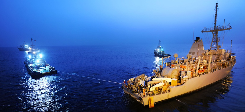 The USS Devastator, a Navy minesweeper, is pulled into position as it arrives in Bahrain in 2012.