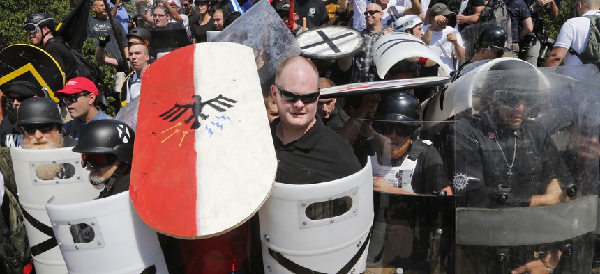 In this Aug. 12, 2017, file photo, white nationalist demonstrators use shields as they guard the entrance to Lee Park in Charlottesville, Va.In this Aug. 12, 2017, file photo, white nationalist demonstrators use shields as they guard the entrance to Lee P