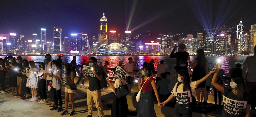 Demonstrators link hands as they gather at the Tsim Sha Tsui waterfront in Hong Kong, Friday, Aug. 23, 2019.