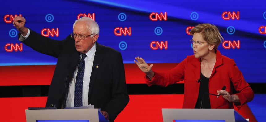 Sen. Bernie Sanders, I-Vt., and Sen. Elizabeth Warren, D-Mass., talk during in the first of two Democratic presidential primary debates hosted by CNN Tuesday, July 30, 2019, in the Fox Theatre in Detroit.