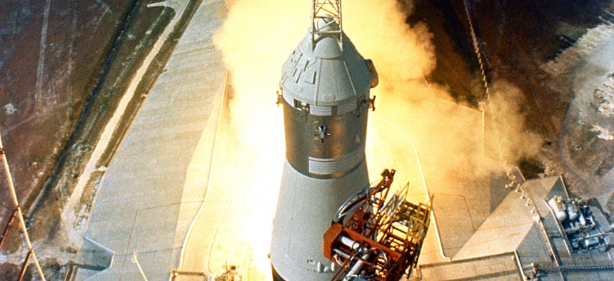 At 9:32 a.m. on July 16, 1969, the swing arms move away and a plume of flame signals the liftoff of the Apollo 11 Saturn V space vehicle.