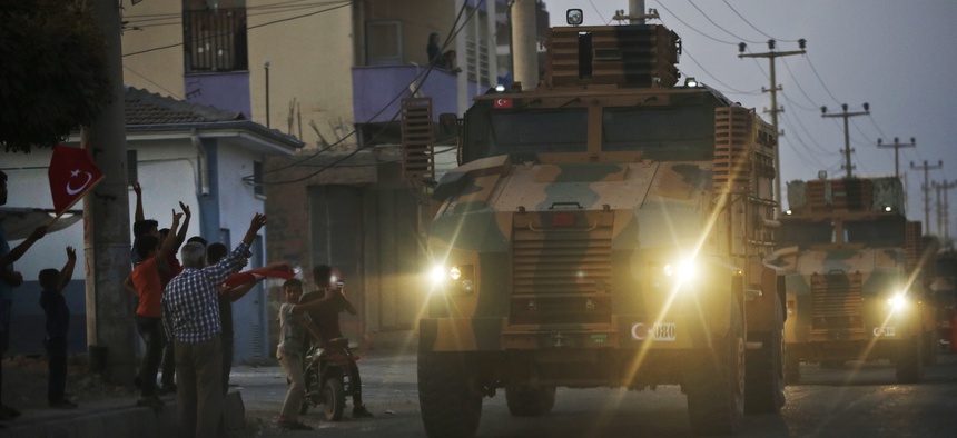 A convoy of Turkish forces vehicles drives through the town of Akcakale, at the border between Turkey and Syria, shortly after Turkey's new ground offensive began, Wednesday, Oct. 9, 2019.