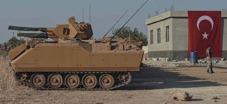 Turkish army personnel carriers are parked on a road towards the border of Syria in Sanliurfa province, Turkey, Monday, Oct. 14, 2019.