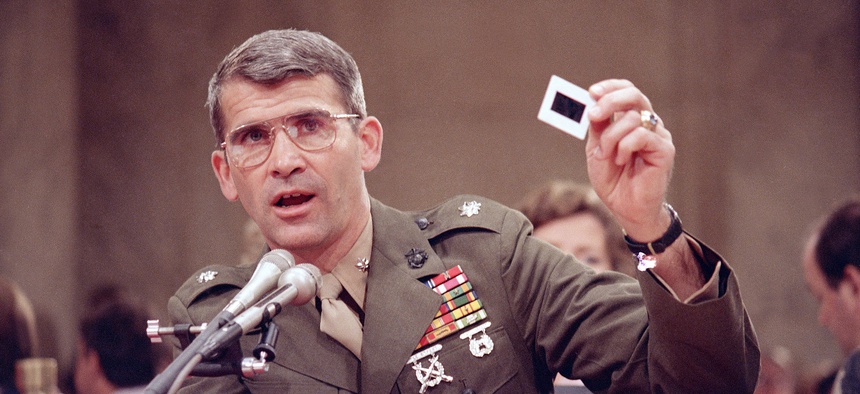Lt. Col. Oliver North delivers a pro-Contra briefing to the members of the Iran-Contra committee Tuesday, July 14, 1987. North is holding each of the 57 slides and describing what they showed.