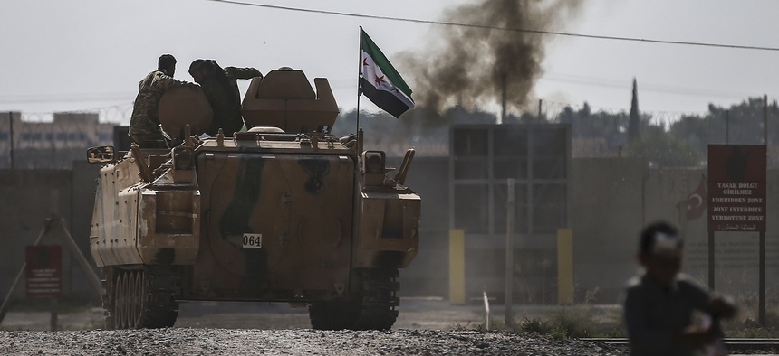 Turkish-backed Syrian opposition fighters on an armoured personnel carrier drive to cross the border into Syria, in Akcakale, Sanliurfa province, southeastern Turkey, Friday, Oct. 18, 2019.