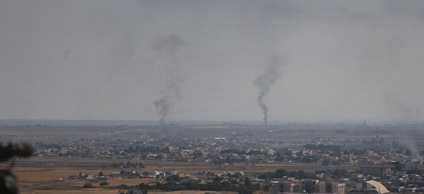 A hilltop in Ceylanpinar, Sanliurfa province, southeastern Turkey, overlooks smoke billowing from fires in Ras al-Ayn, Syria, Sunday, Oct. 20, 2019.