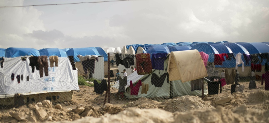 In this Sunday, March 31, 2019 file photo, laundry dries on a chain link fence in an area for foreign families, at al-Hol camp in Hasakeh province, Syria.