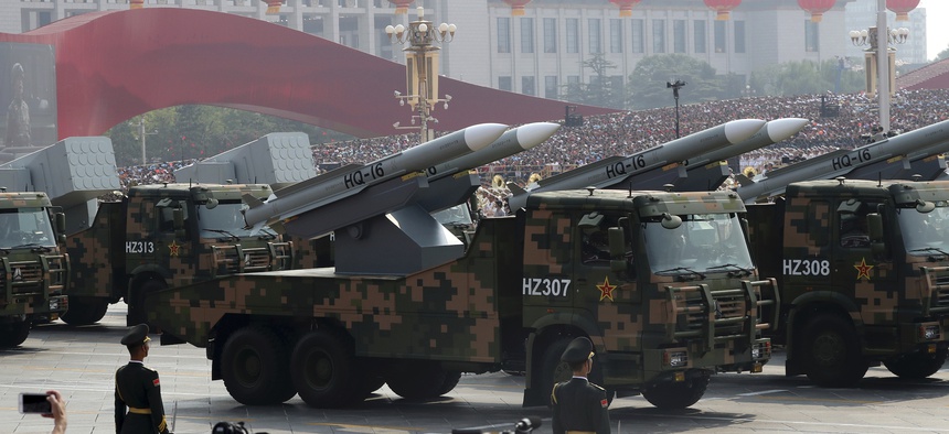 Military vehicles roll down as members of a Chinese military honor guard march during the celebration to commemorate the 70th anniversary of the founding of Communist China in Beijing, Tuesday, Oct. 1, 2019.