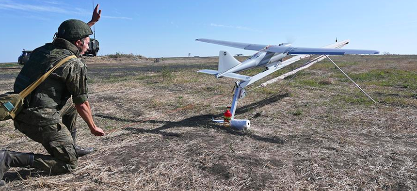 A Russian soldier launching an Orlan-10 drone