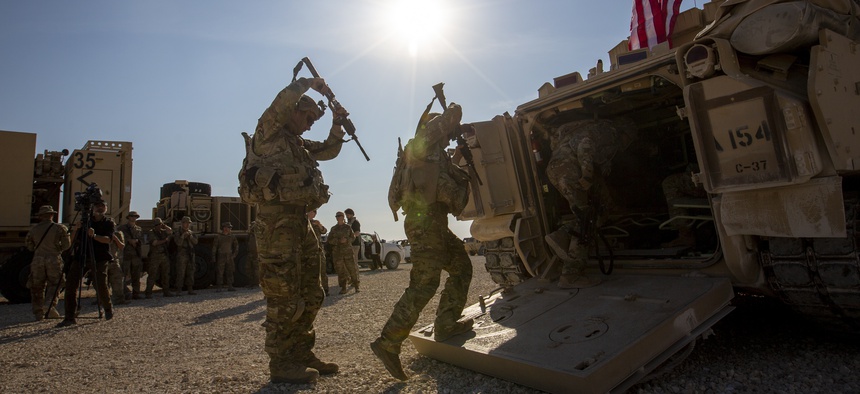 Crewmen enter Bradley fighting vehicles at a US military base in northeastern Syria, Monday, Nov. 11, 2019.
