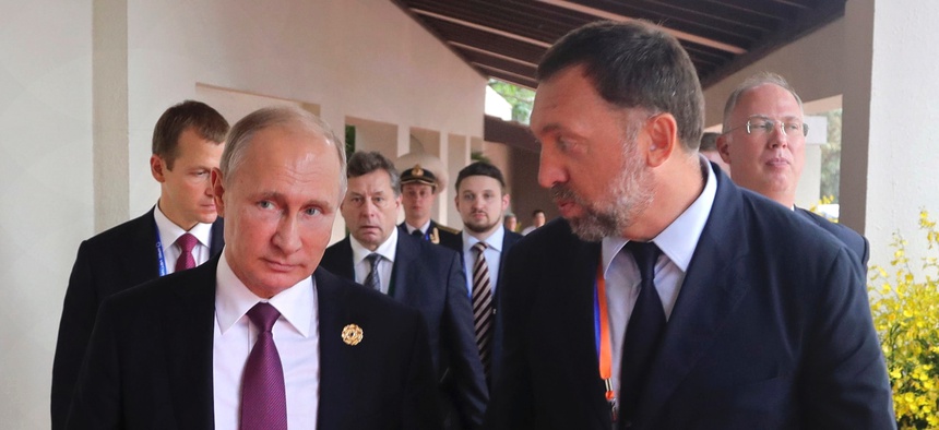 This Nov. 10, 2017, file photo shows Russia's President Vladimir Putin, left, and Russian metals magnate Oleg Deripaska, right, walking to attend the APEC Business Advisory Council dialogue in Danang, Vietnam.