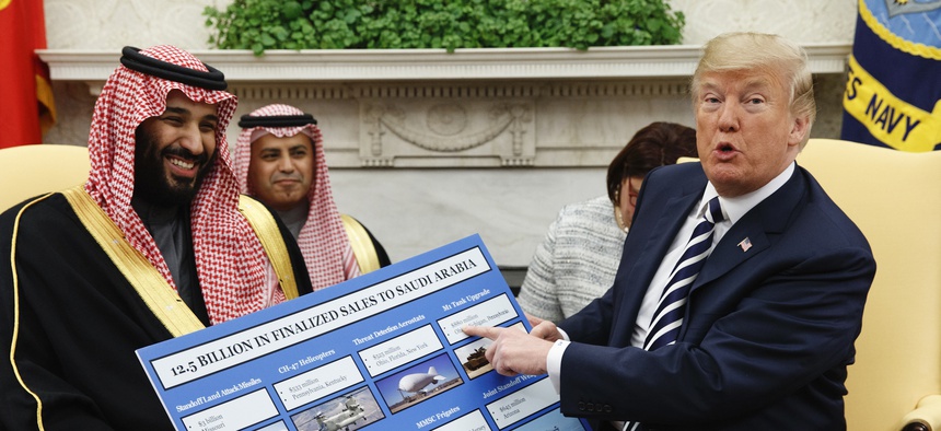 President Donald Trump shows a chart highlighting arms sales to Saudi Arabia during a meeting with Saudi Crown Prince Mohammed bin Salman in the Oval Office of the White House in Washington on March 20, 2018.