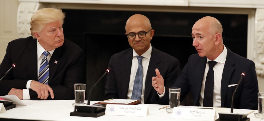 In this June 19, 2017, file photo President Donald Trump, left, and Satya Nadella, Chief Executive Officer of Microsoft, center, listen as Jeff Bezos, Chief Executive Officer of Amazon, speaks during an American Technology Council roundtable.