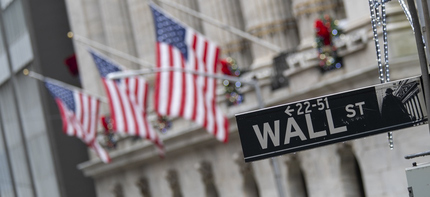 The Wall St. street sign is framed by American flags flying outside the New York Stock Exchange, Friday, Jan. 3.